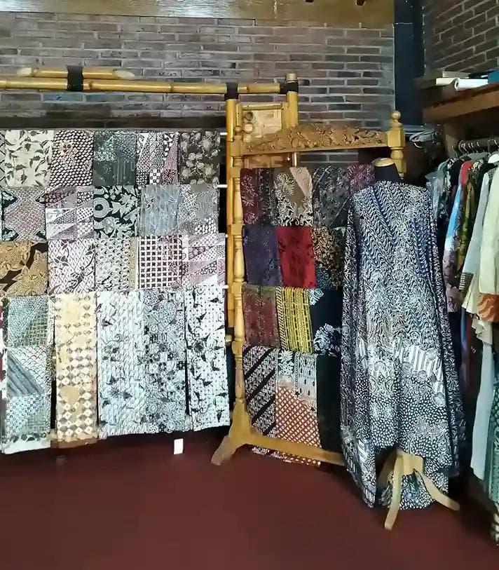 Display koleksi kain dan busana batik tradisional.