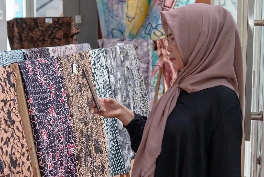Pengunjung melihat koleksi kain batik di showroom