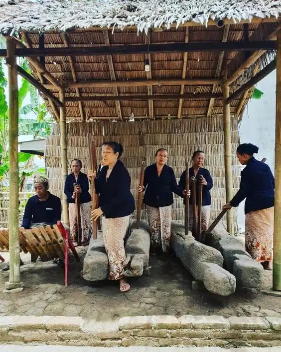 Ibu-ibu Suku Osing berkebaya melakukan tradisi othek (gedhogan), menabuh lesung secara berirama