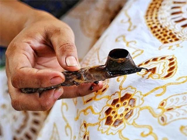 Perajin batik menggunakan canting