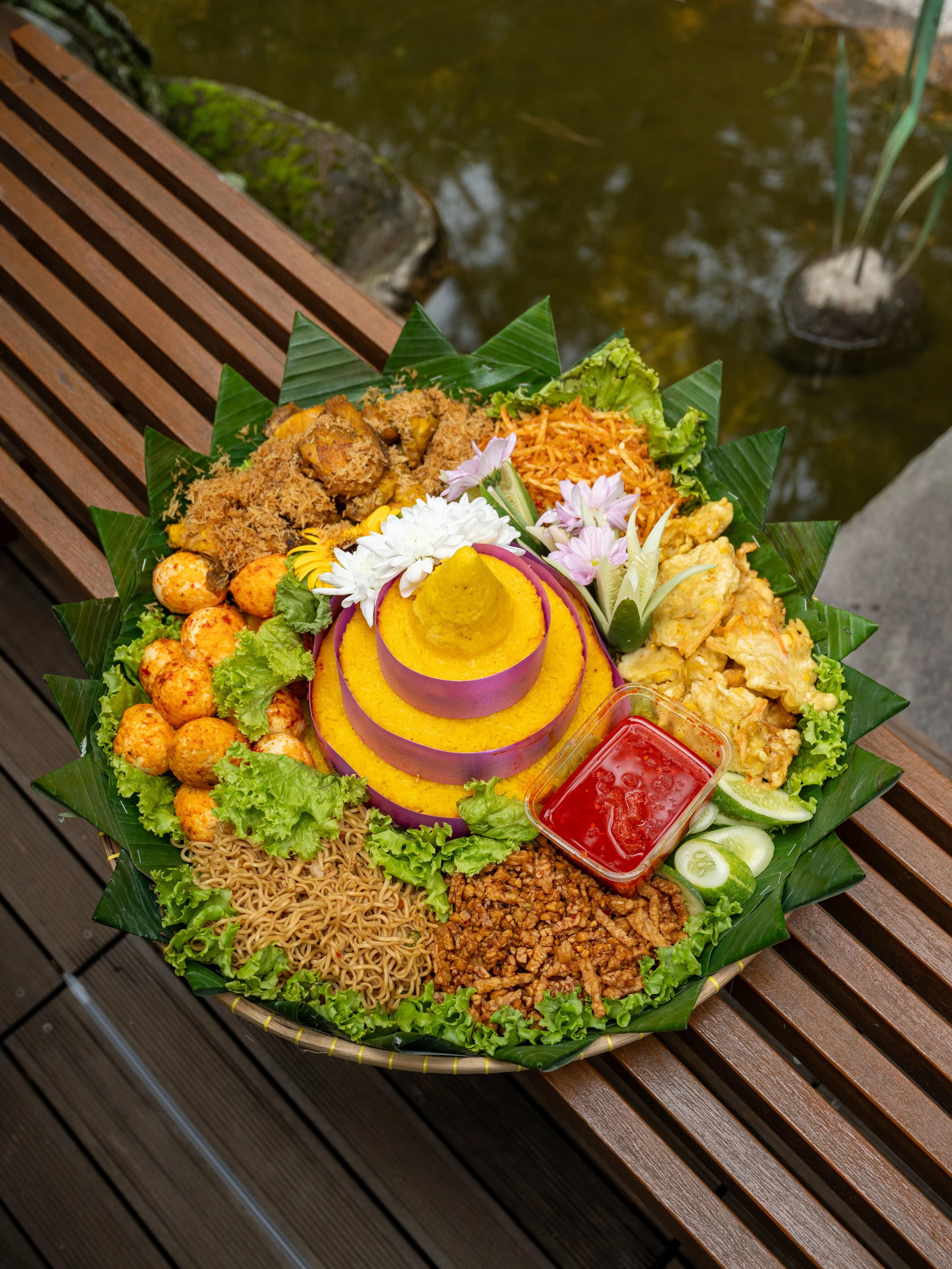 Tumpeng nasi kerucut dengan lauk pecel pitik, hidangan khas tradisi Tumpeng Sewu Banyuwangi