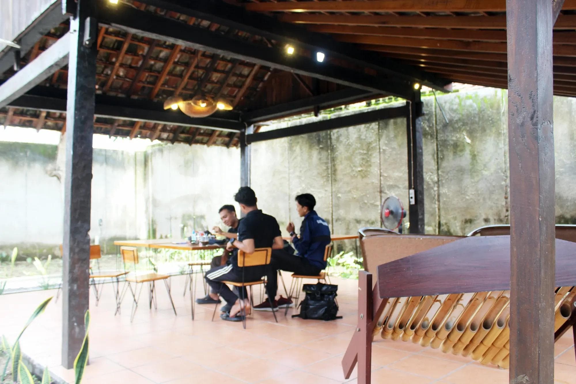 Area coworking semi-outdoor untuk bekerja dan berdiskusi