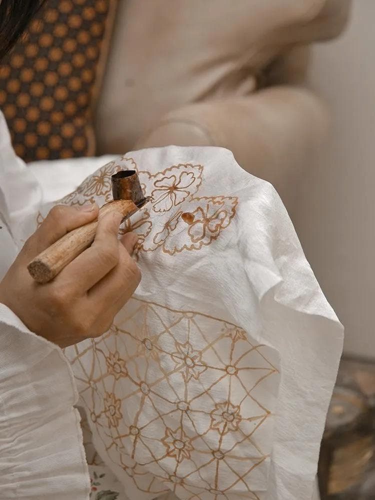 Proses membatik menggunakan canting pada kain