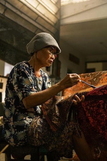 Perajin batik sedang mengerjakan kain batik tulis