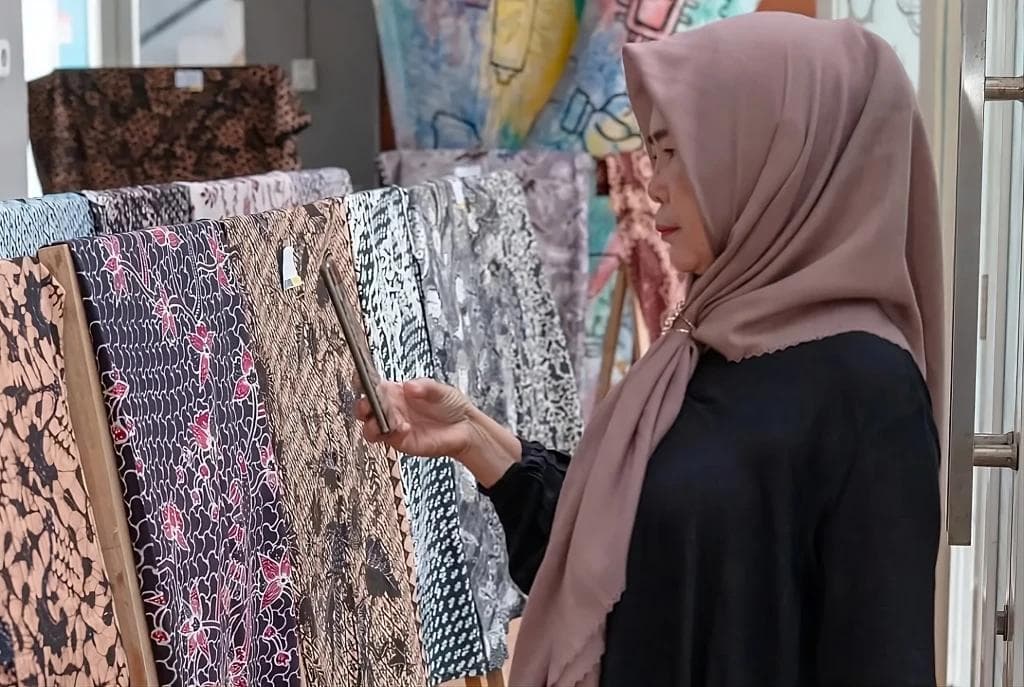 Pengunjung melihat koleksi kain batik di showroom